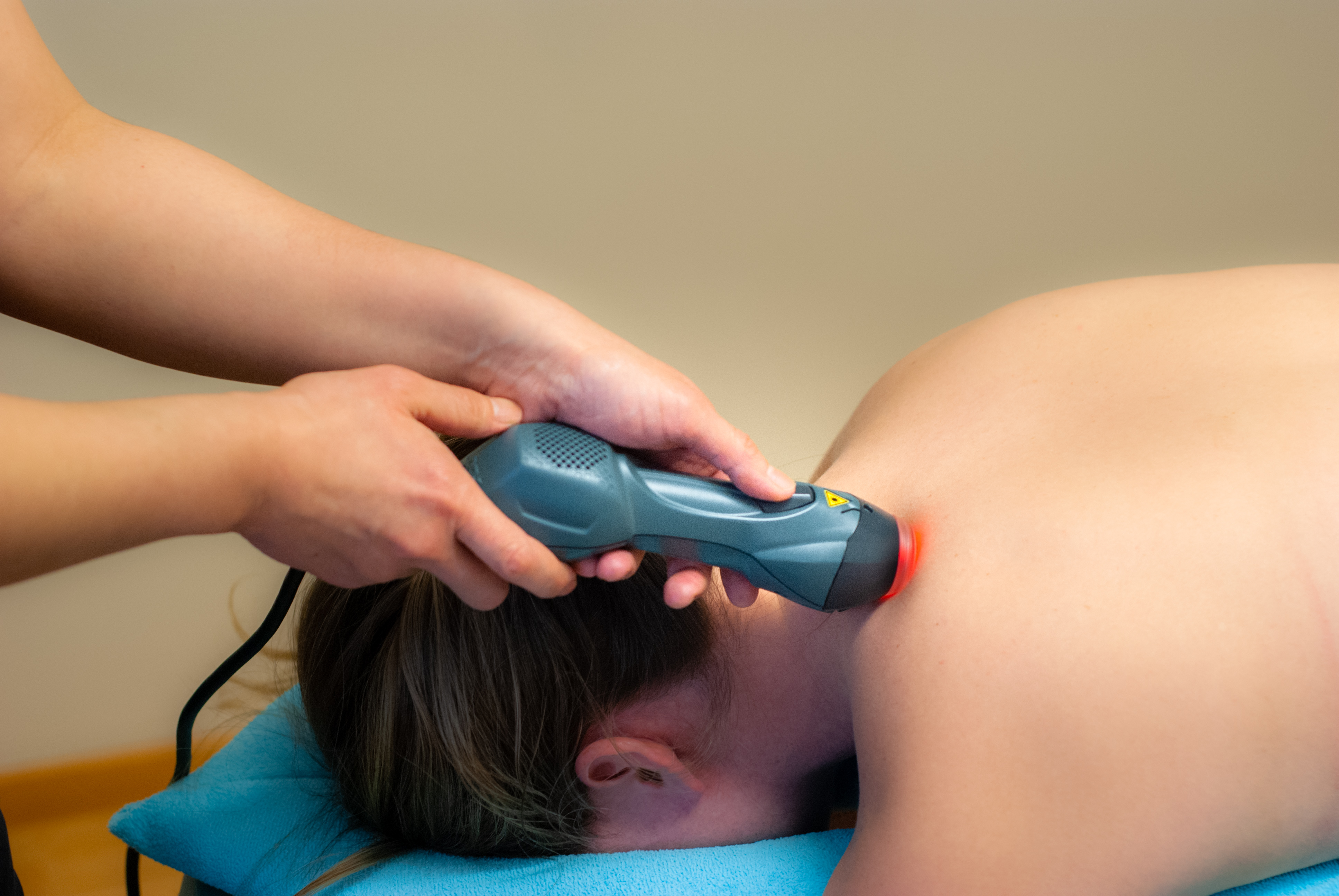 Laserterapi - En patient får sin axel behandlad med laserterapi med en apparat